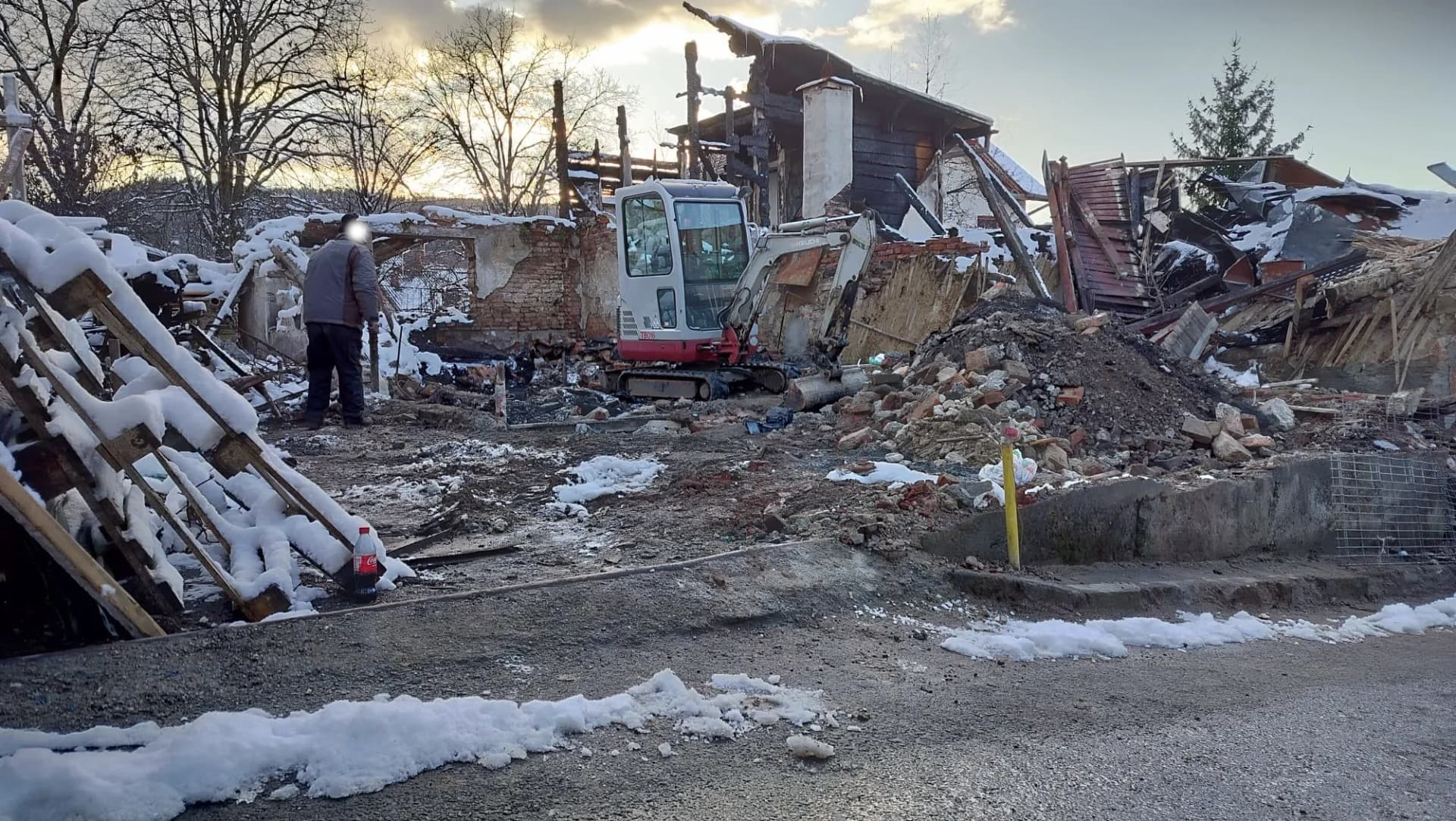 Debarasare a unei construcții incendiate cu mini excavator, pe timp de iarnă
