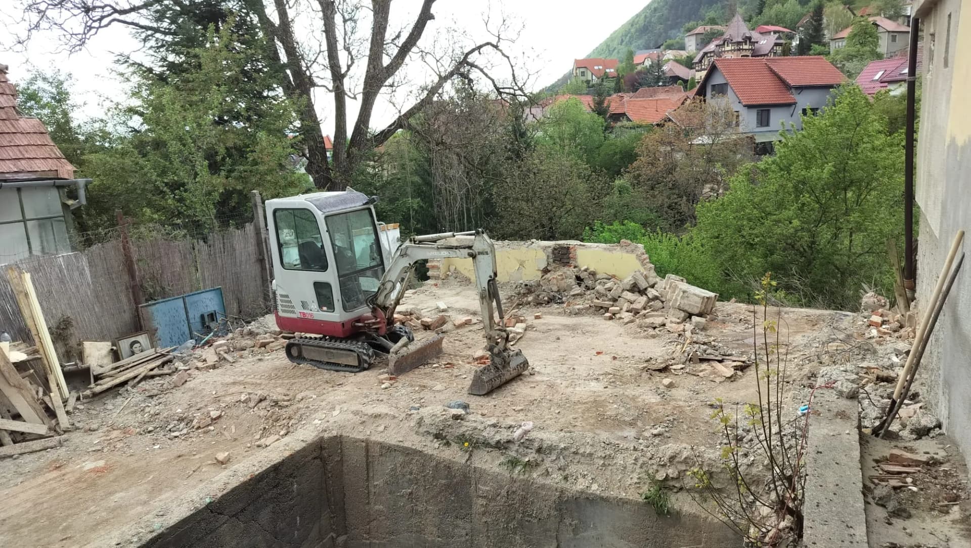 Mini excavator pe teren decopertat, pregătit pentru amenajare