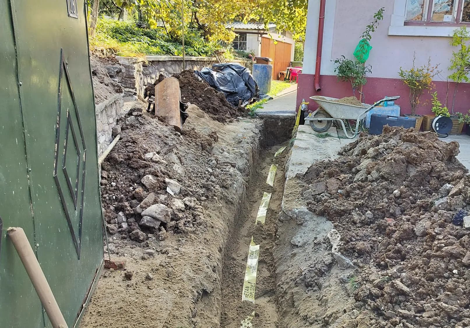 Șanț îngust săpat lângă curte pentru montaj de utilități