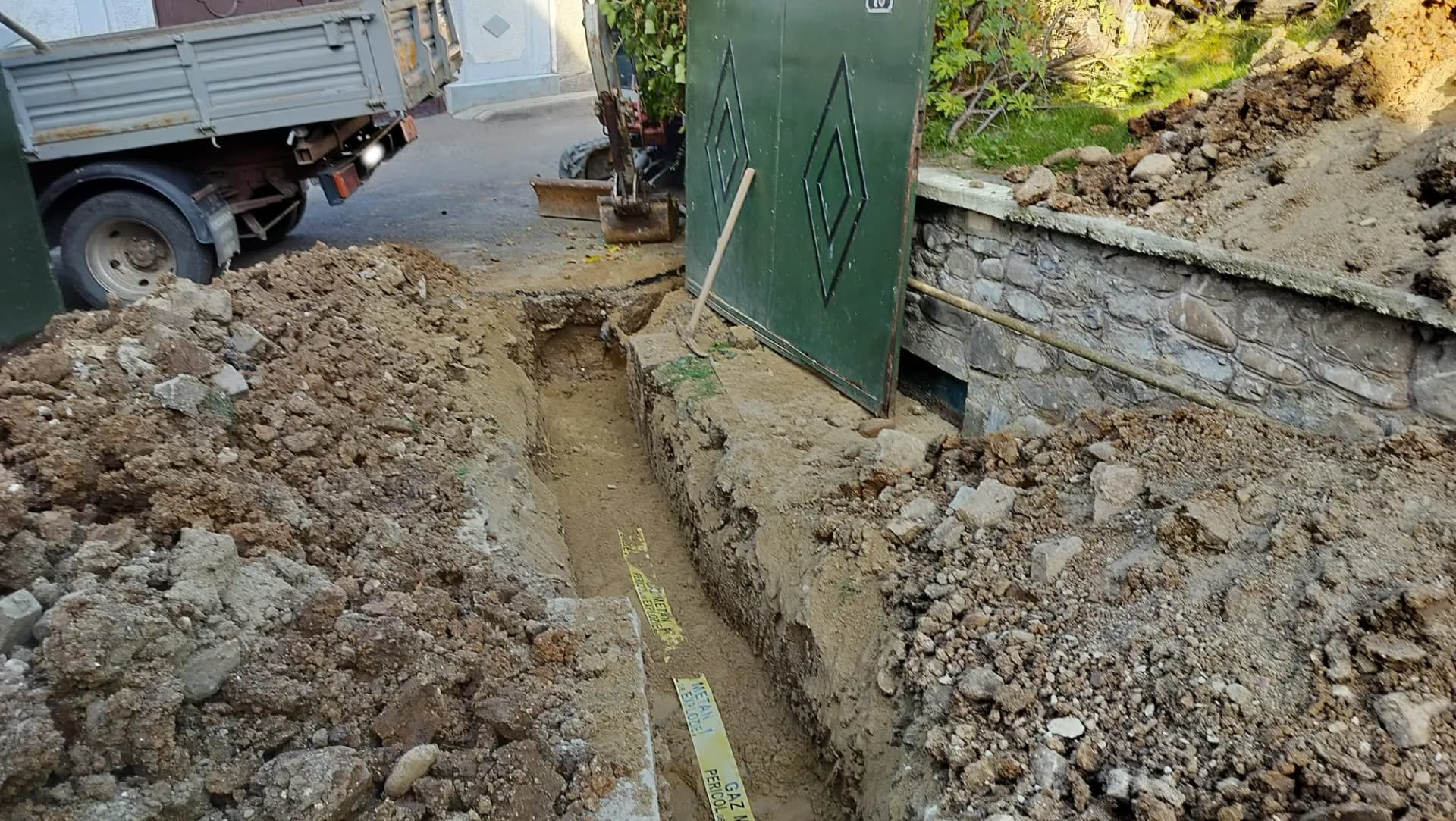 Săpătură de utilități realizată la intrarea în curte, lângă poartă